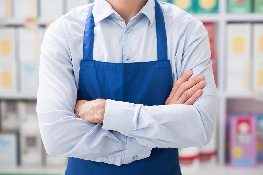 Shop assistant posing at the supermarket with arms crossed retail job concept unrecognizable person
