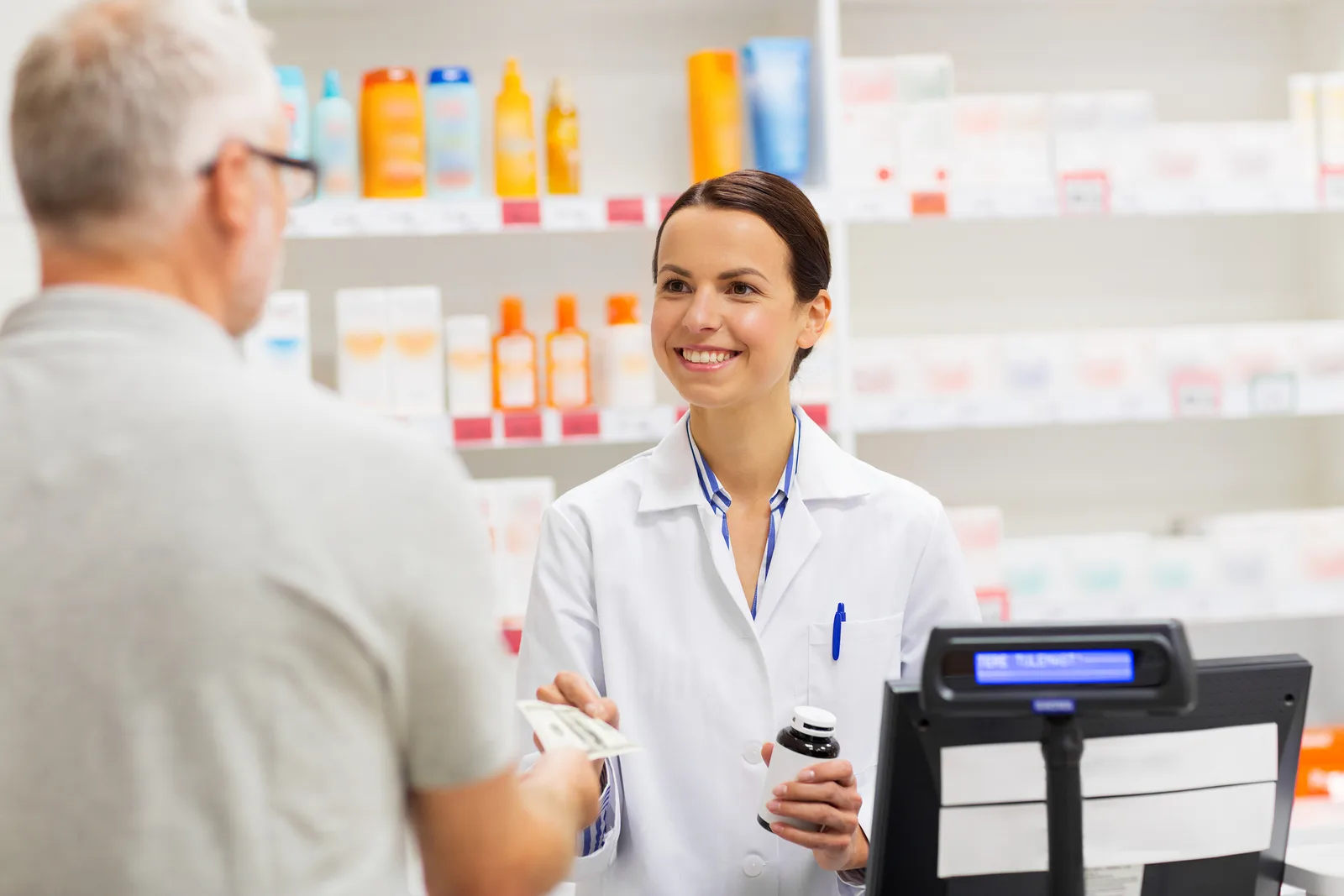 medicine, pharmaceutics, health care and people concept - apothecary and senior man customer buying drug at drugstore