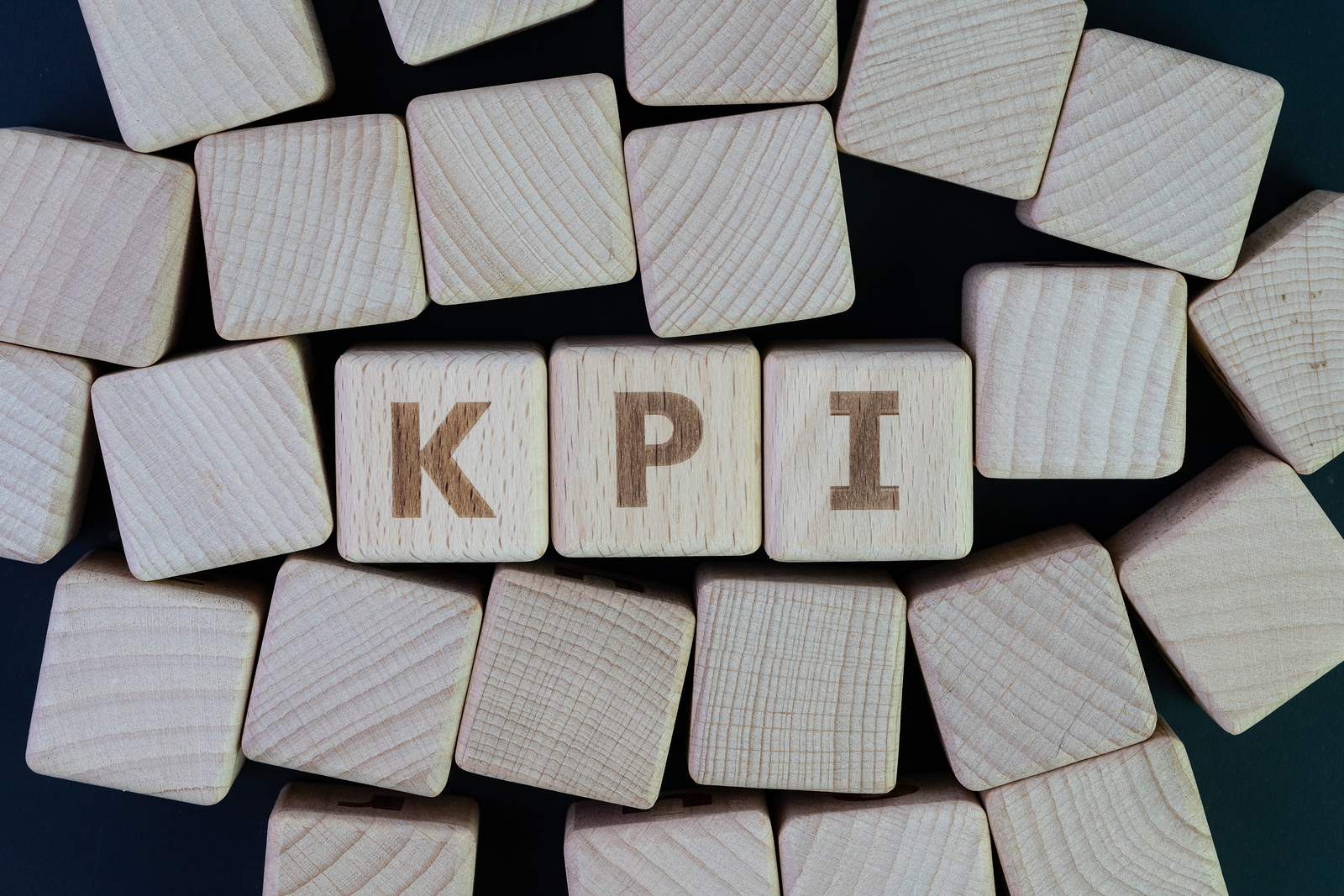 KPI, Key Point Indicator business success measurement target and goal management concept, cube wooden block with alphabet building the word KPI on blackboard.