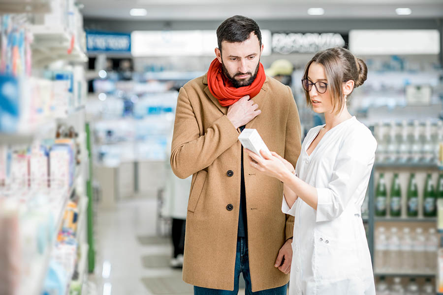 pharmacists helps customer with cold remedy
