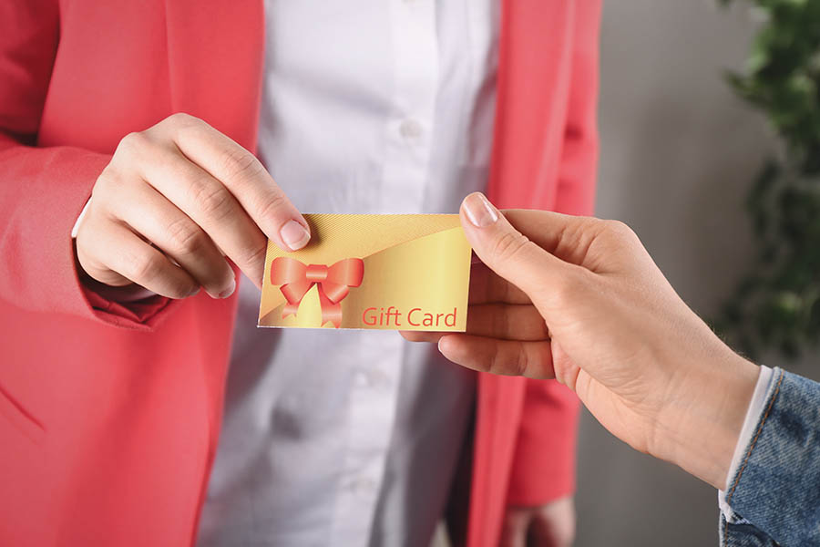 Women with gift card on blurred background, closeup