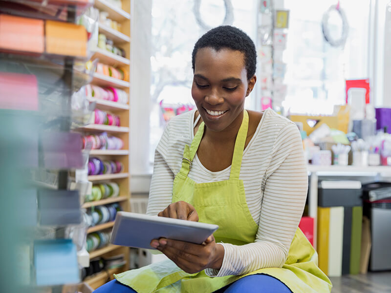 Female small business owner taking inventory with digital tablet