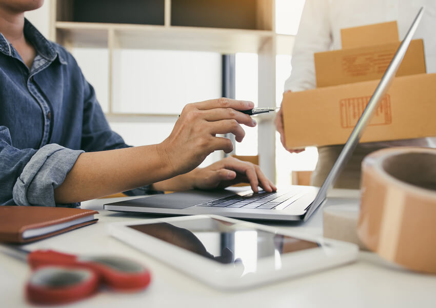 Two business owner are working together to pack products and check customers' orders