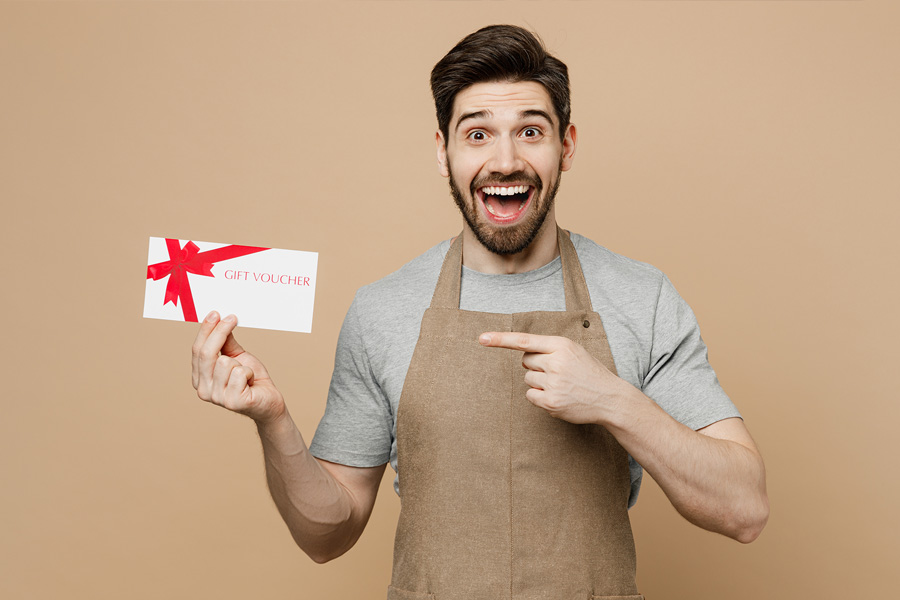 Young man employee pointing finger at gift card software coupon