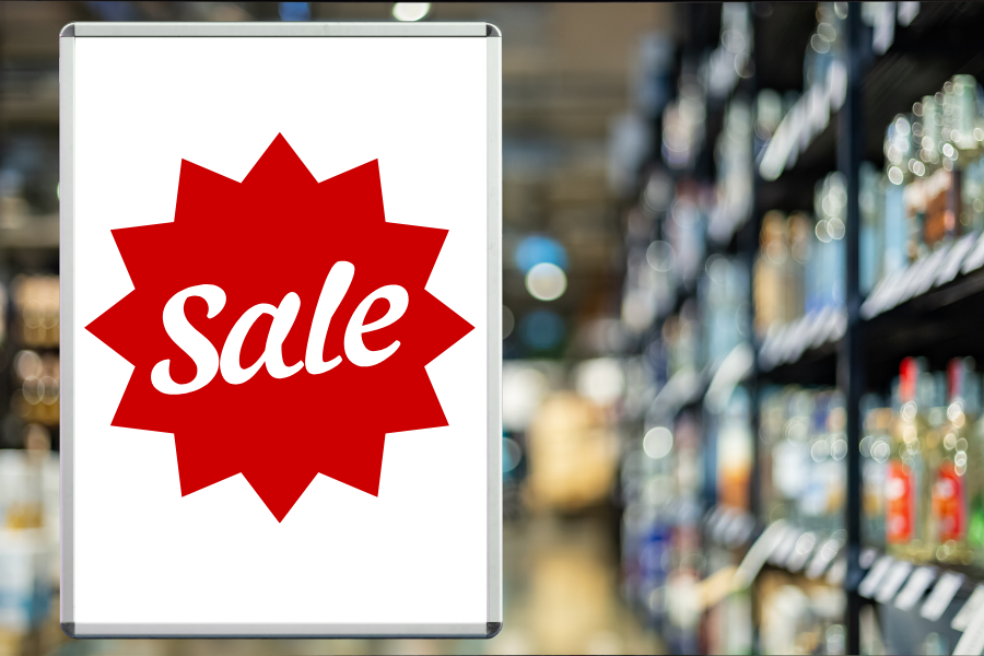 Red “Sale” sign displayed in a liquor store aisle, symbolizing effective promotions managed through a liquor store POS system.
